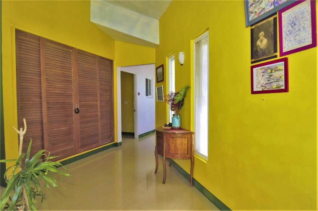 a yellow hallway with a table and a window at Kenting COMIC B&amp;B in Hengchun South Gate