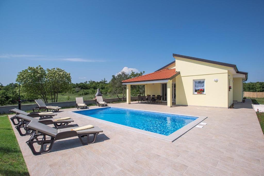 una piscina con dos sillas y una casa en Villa Fiorina, en Krnica