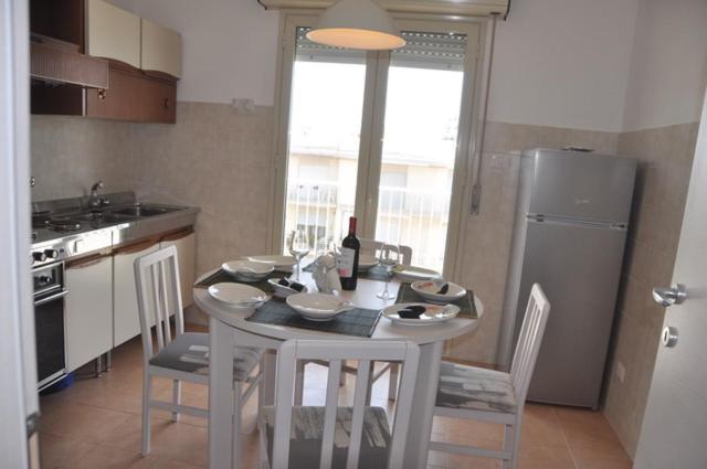 eine Küche mit einem Tisch mit Stühlen und einem Kühlschrank in der Unterkunft la Moretta in Marina di Ragusa