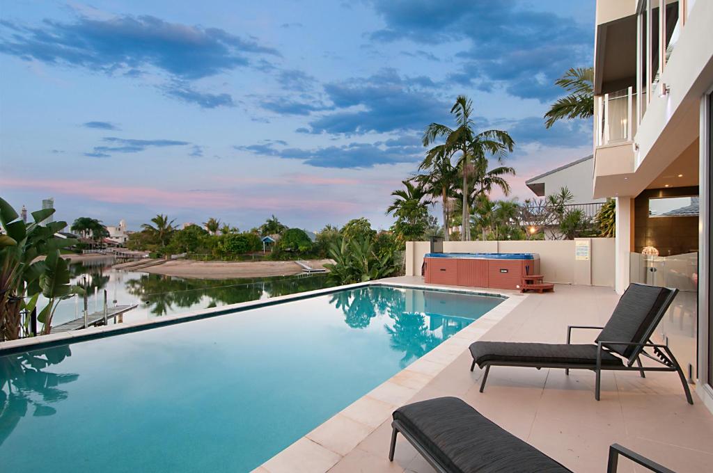 einem Pool mit einem Stuhl und einem Gebäude in der Unterkunft Opulence on Broadbeach in Gold Coast