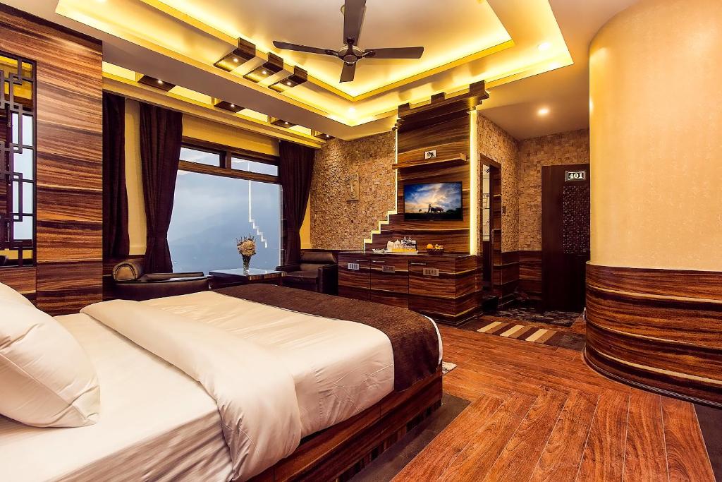 a bedroom with a bed and a flat screen tv at Amba Regency in Gangtok