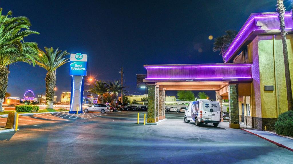 uma carrinha branca estacionada numa bomba de gasolina à noite em Best Western McCarran Inn em Las Vegas
