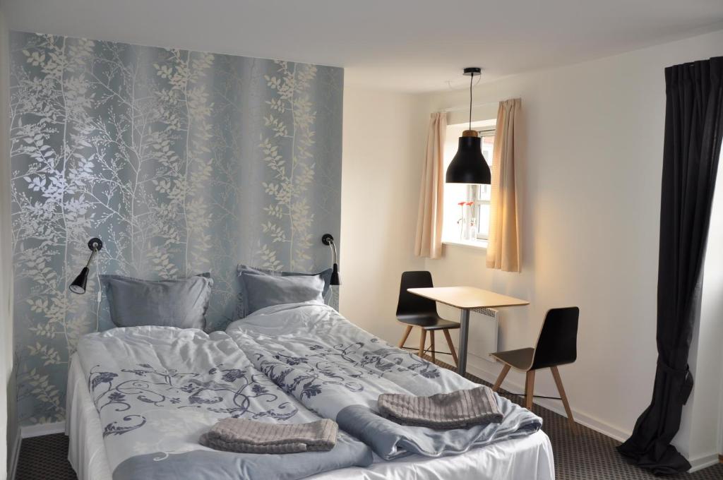 - une chambre avec un lit, une table et des chaises dans l'établissement Lundsgaard Bed & Breakfast, à Fåborg
