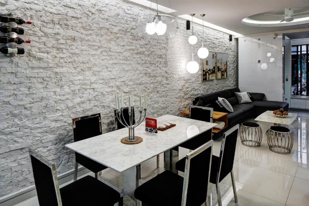 a dining room and living room with a white brick wall at HL53 B&amp;B in Hualien City
