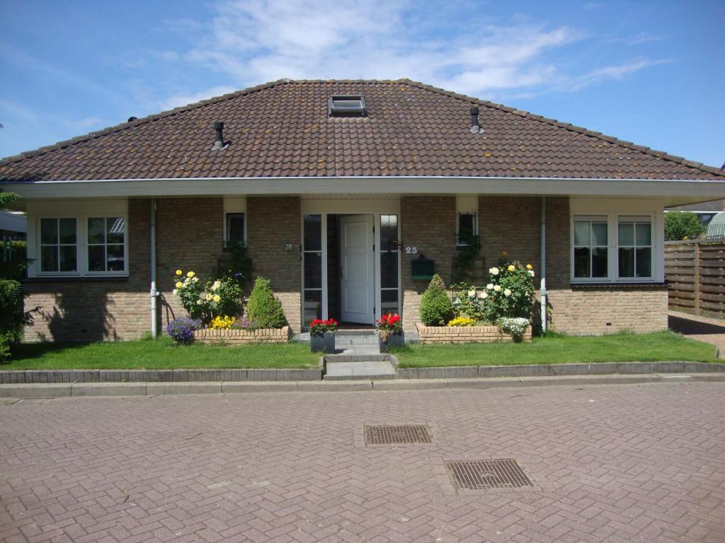 een stenen huis met bloemen in de voortuin bij Valckesteyn in Poortugaal