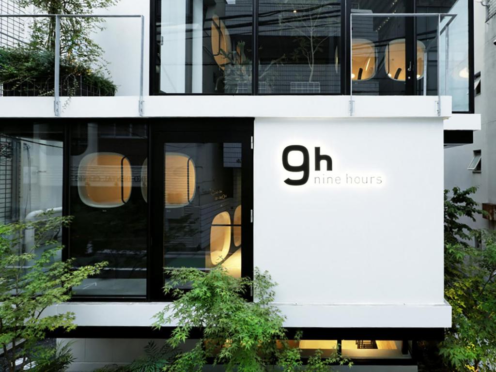 a building with a sign for the chi omega house at 9h nine hours Akasaka sleep lab in Tokyo