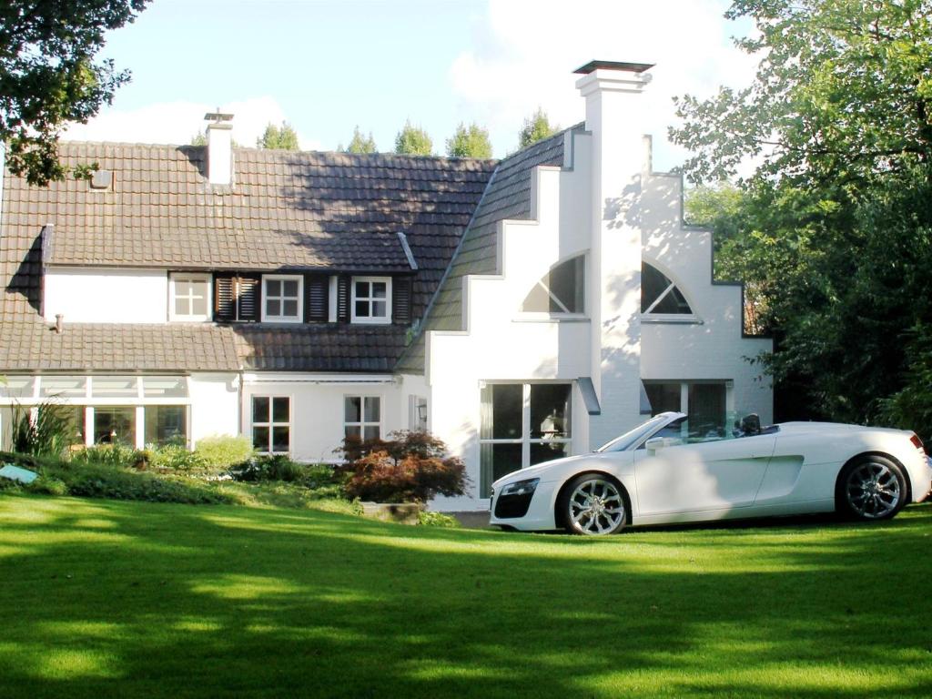 een witte auto geparkeerd voor een huis bij Villa EMG in Emsdetten
