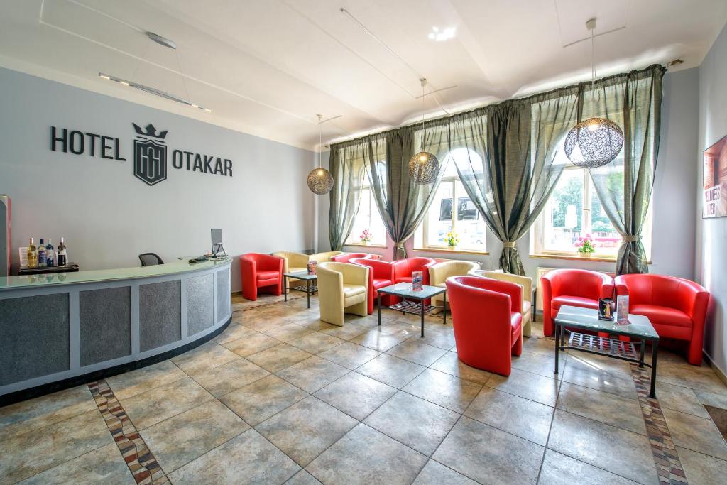 a hotel lobby with red chairs and a waiting room at Hotel Otakar in Prague