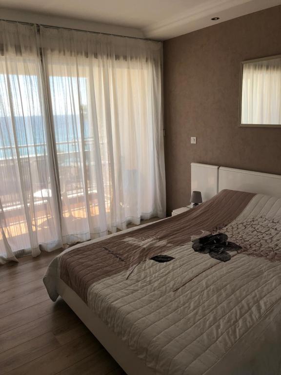 カンヌにあるBord de Mer Cannes Midiの大きな窓付きのベッドルーム1室