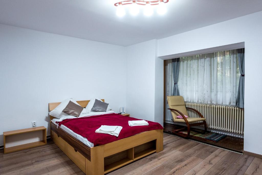- une chambre avec un lit et une couverture rouge dans l'établissement D&O Boemia, à Timişoara