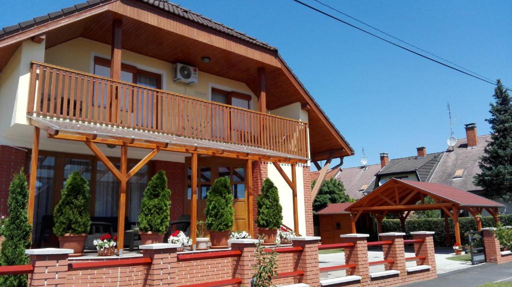 a house with a balcony on the side of it at Marina-Bük Apartmanház in Bük