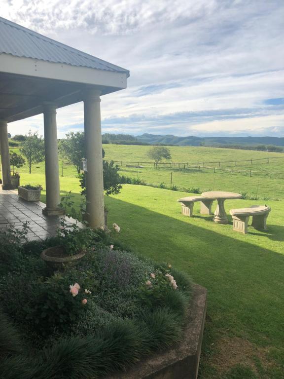 eine Gruppe von Bänken, die auf einem Feld sitzen in der Unterkunft Thyme Out Weltevreden Farm in Curryʼs Post