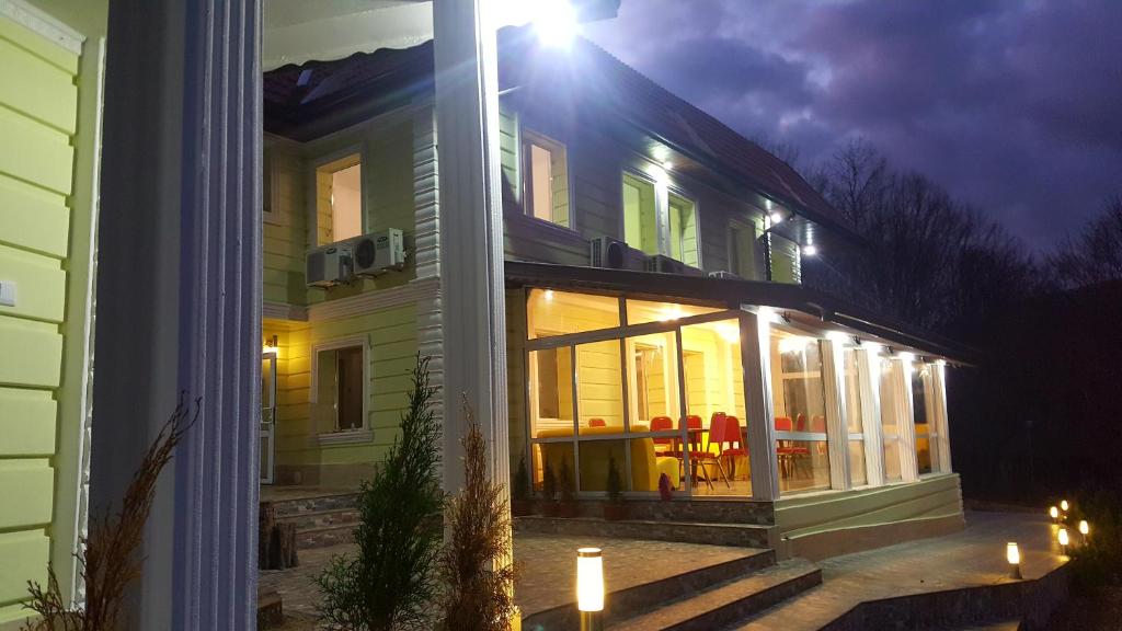 une maison avec une véranda éclairée la nuit dans l'établissement Hotel & Restaurant Kotel, à Kotel