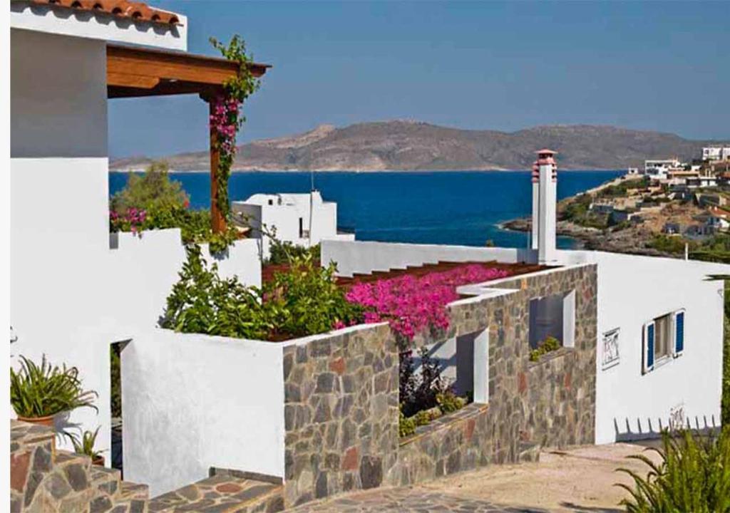 a house with flowers on the side of it at Periyali in Keratea