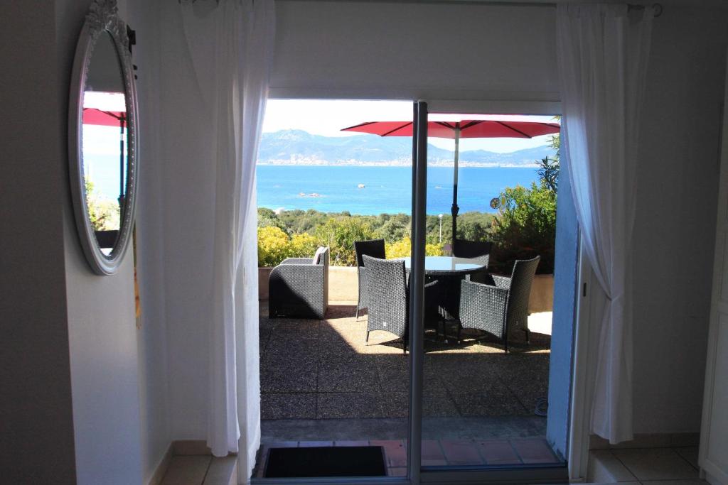 einen Balkon mit einem Tisch und einem Sonnenschirm in der Unterkunft Villa Ghiatone in Pietrosella