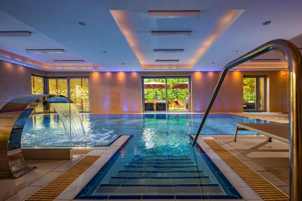 Betekints Wellness Hotel في فيسبرم: مسبح بزحليقة مائية في غرفة الفندق