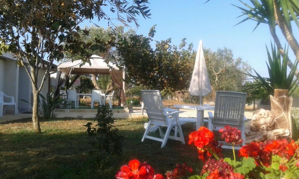ガラトーネにあるVilla Annalaura Galatoneの庭にテーブルと椅子2脚と傘
