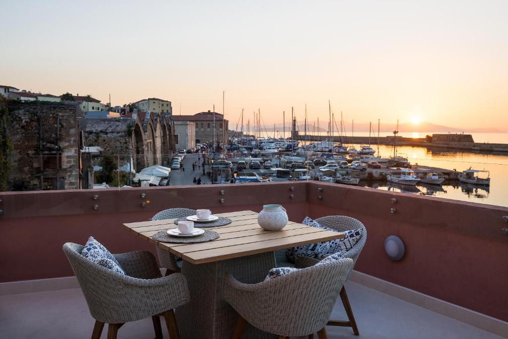 - une table sur un balcon avec vue sur le port dans l'établissement Avra Apartments Venetian Harbour, à La Canée