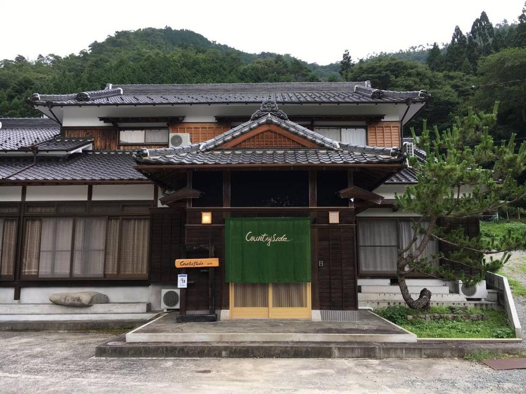 a building with a green sign on the front of it at 宍粟片山 in Shiso