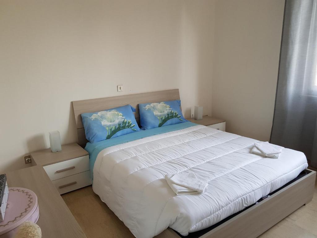 a bedroom with a large bed with blue pillows at Eagle Rooms in Riva del Garda
