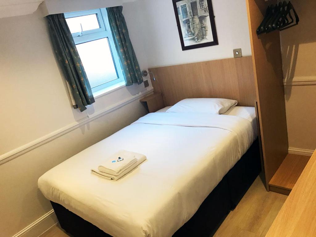 2 camas en una habitación pequeña con ventana en Brentwood Guest House Hotel, en Brentwood