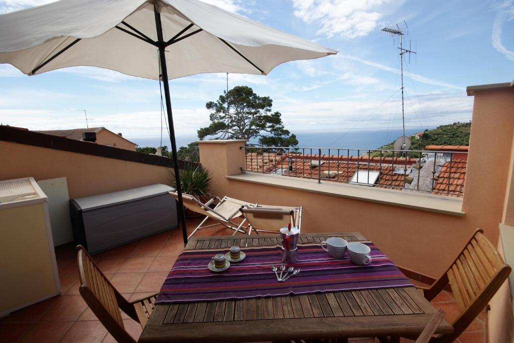 einen Tisch mit Sonnenschirm auf dem Balkon in der Unterkunft Appartamento Galileo in Poggi