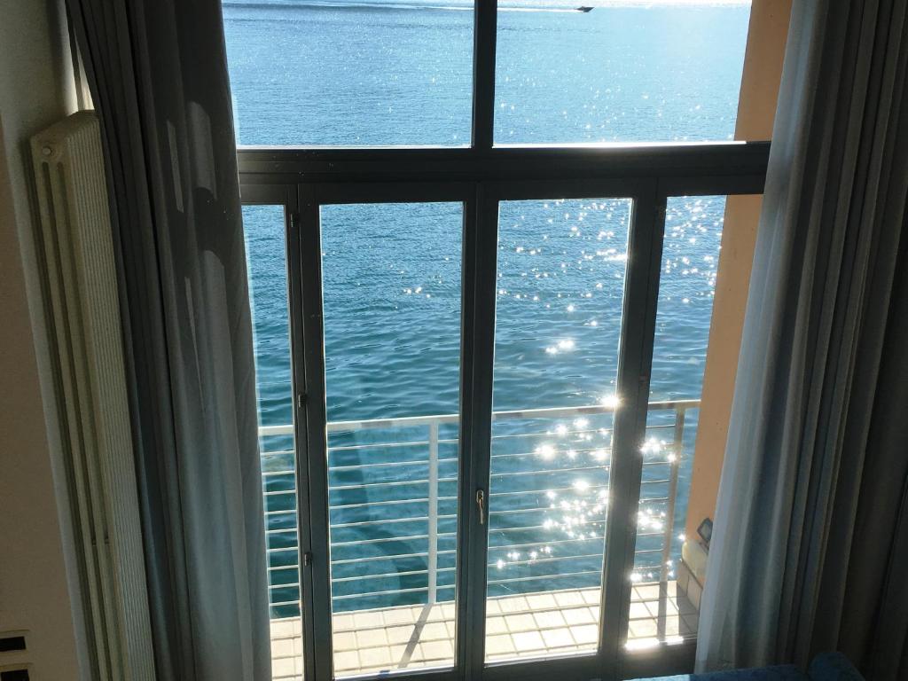 uma vista para o oceano a partir da janela de um quarto de hotel em Apartments Excelsior em Riva del Garda