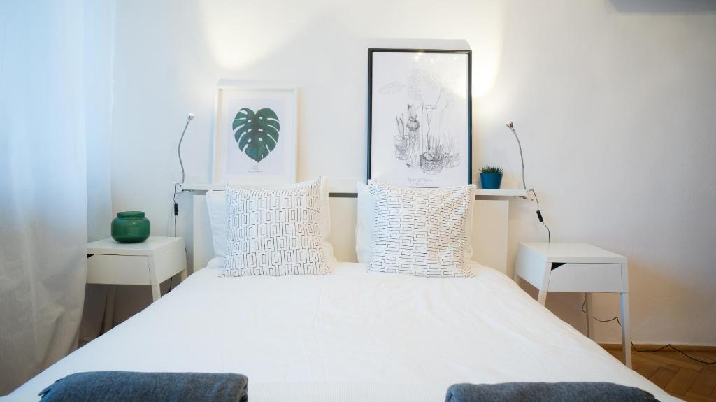 um quarto com uma cama branca e almofadas brancas em Sunny Apartment em Varsóvia