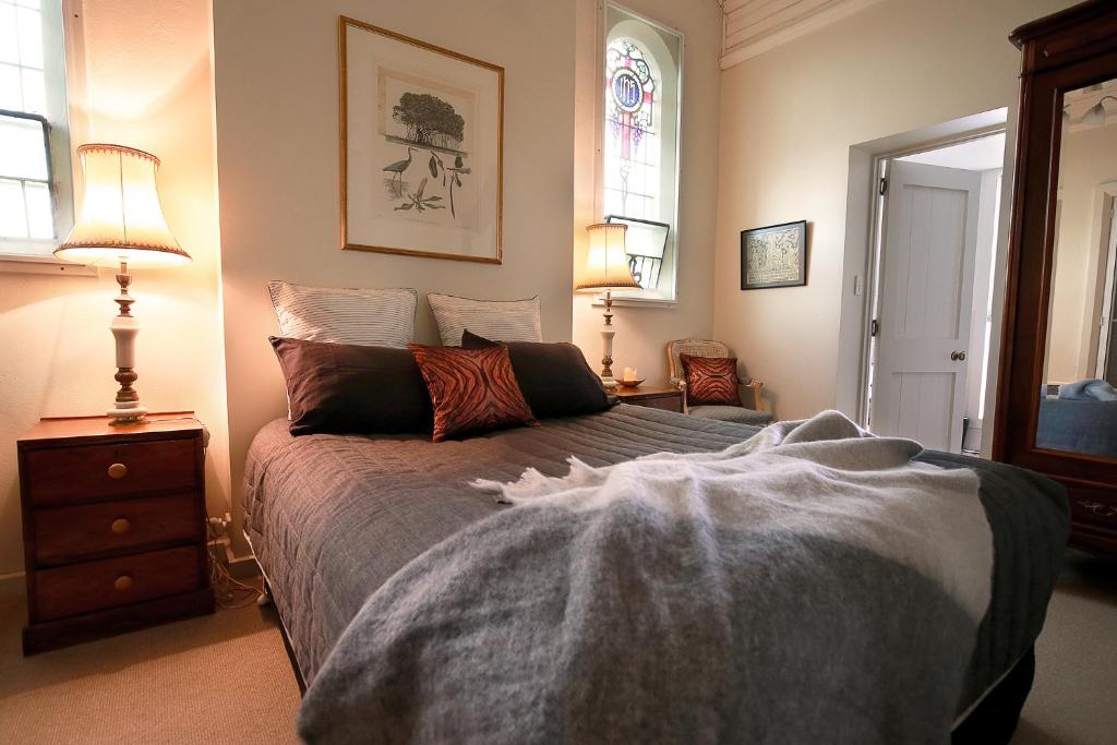 - une chambre avec un lit, deux lampes et une fenêtre dans l'établissement A Tassie Church, à Kempton