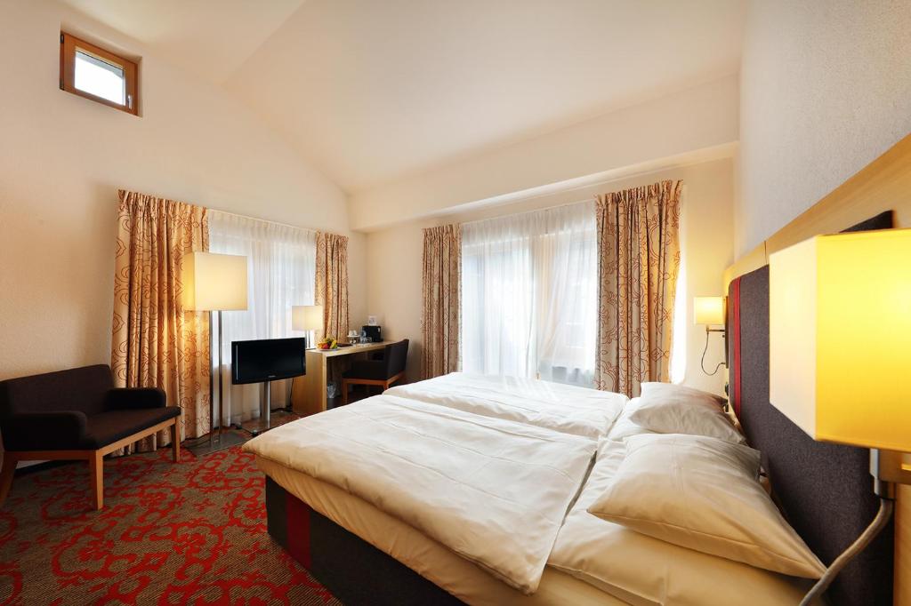 Habitación de hotel con cama grande y ventana en Hotel Garni Testa Grigia, en Zermatt