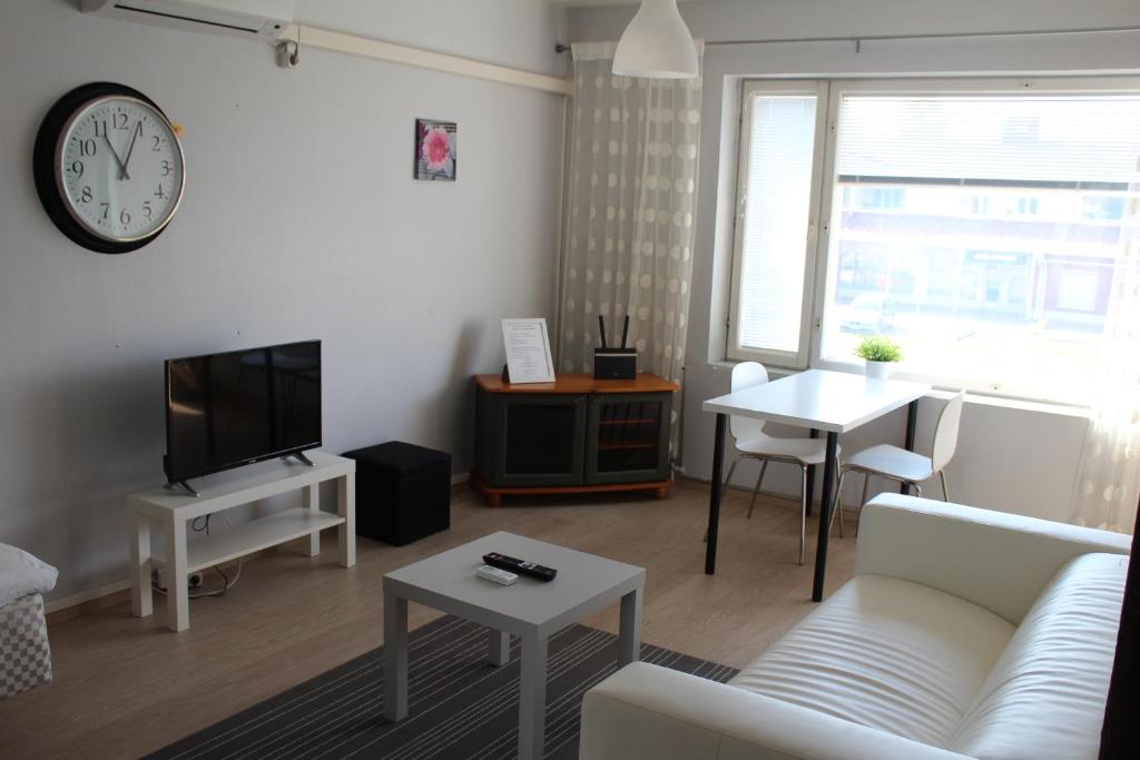 - un salon avec un canapé et un réveil sur le mur dans l'établissement Apartment Vanhatie 44, à Pyhäjoki