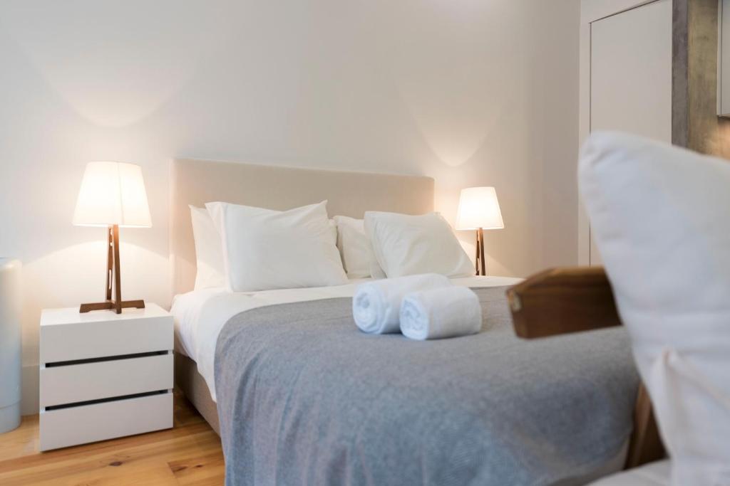 ポルトにあるLovelyStay - Rico's Apartment - Almada 1ºFのベッドルーム1室(タオル2枚、ベッド1台、ランプ2つ付)