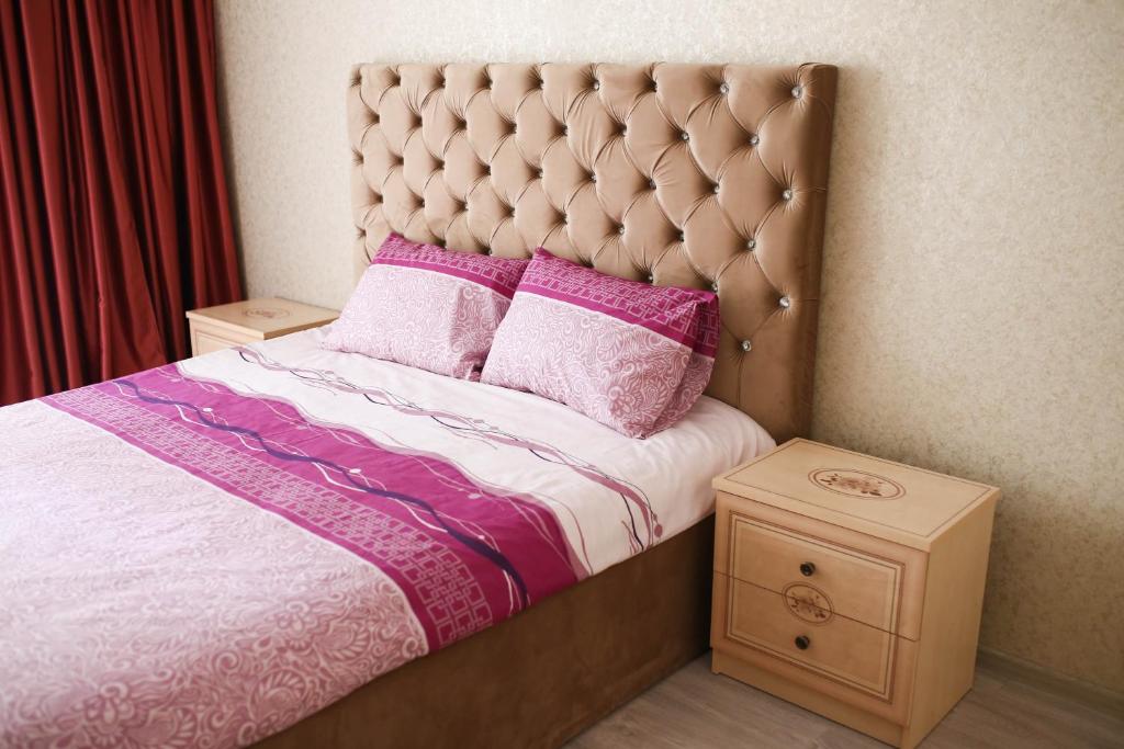 リヴィウにあるBilya Taurusuのベッドルーム1室(ピンクと紫の枕が付いたベッド1台付)
