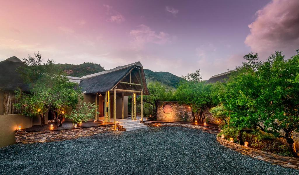 a home with a gravel driveway and a house at Lush Private Game Lodge in Pilanesberg