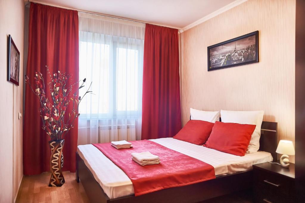 マグニトゴルスクにあるFive Stars In the Centreのベッドルーム1室(赤い枕のベッド1台、窓付)