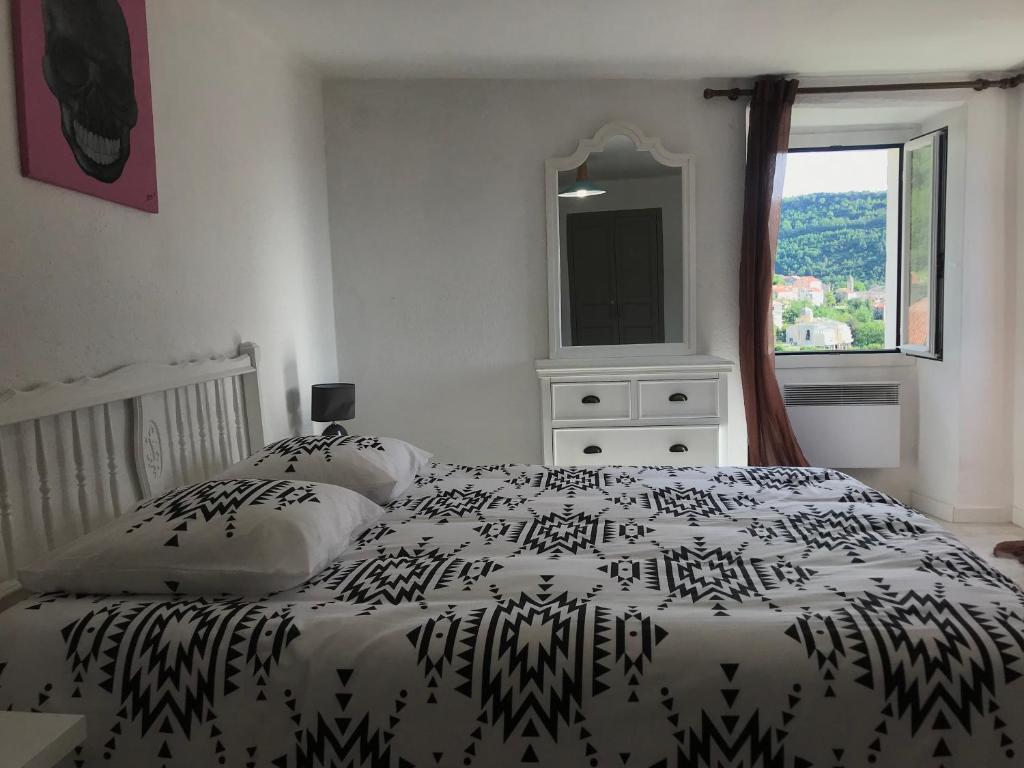 una camera con un letto bianco e nero e una finestra di Maison entière tout équipé 4 chambre possibilité de 10 couchage Venaco Centre Corse a Venaco