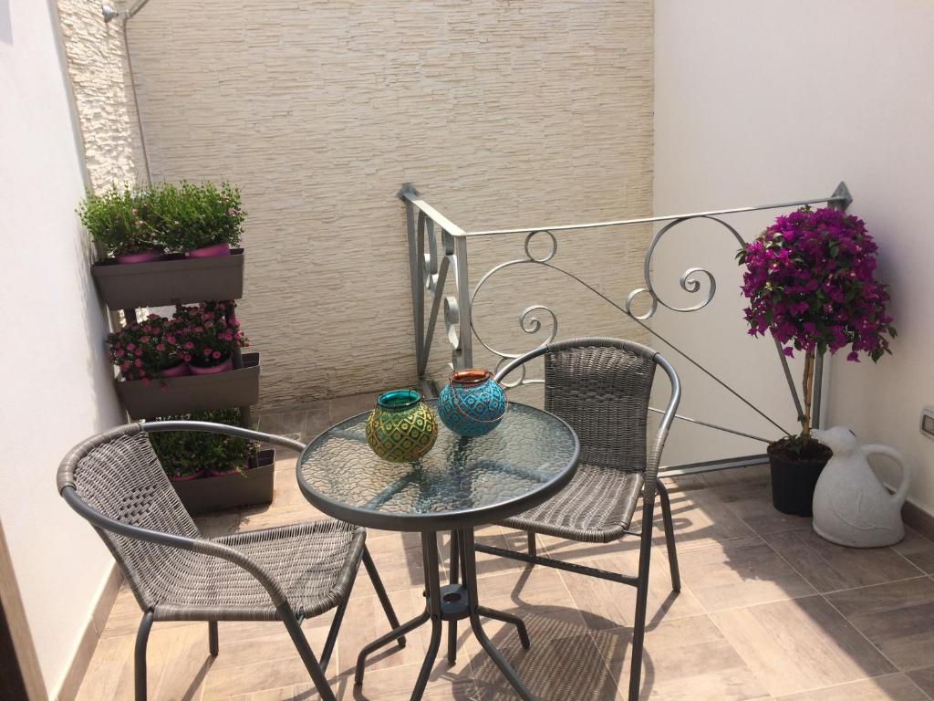 a glass table and two chairs with vases on it at Dimore di Mare in San Pietro Vernotico