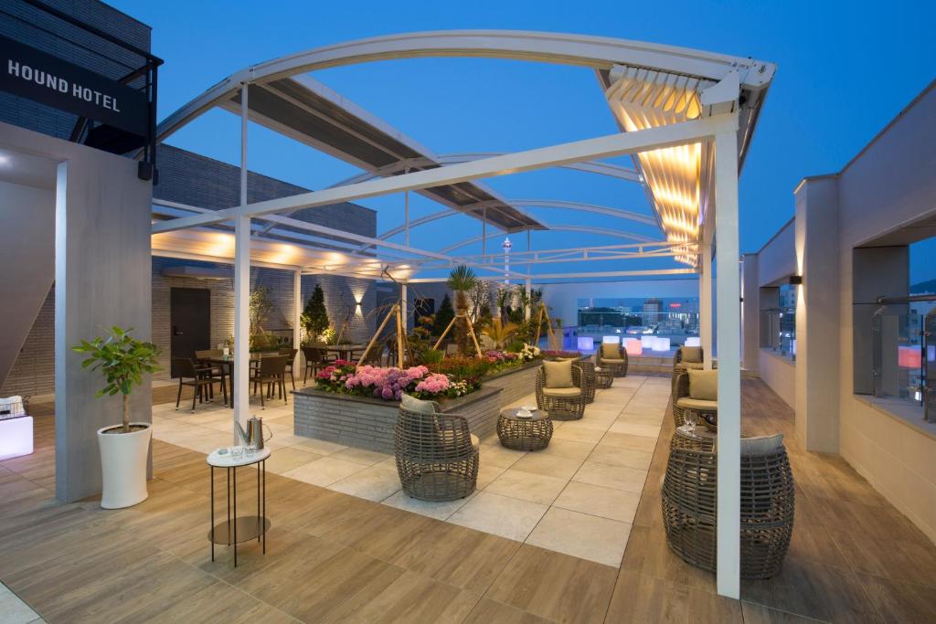 a patio with chairs and tables on a building at Nampo Hound Hotel Premier in Busan