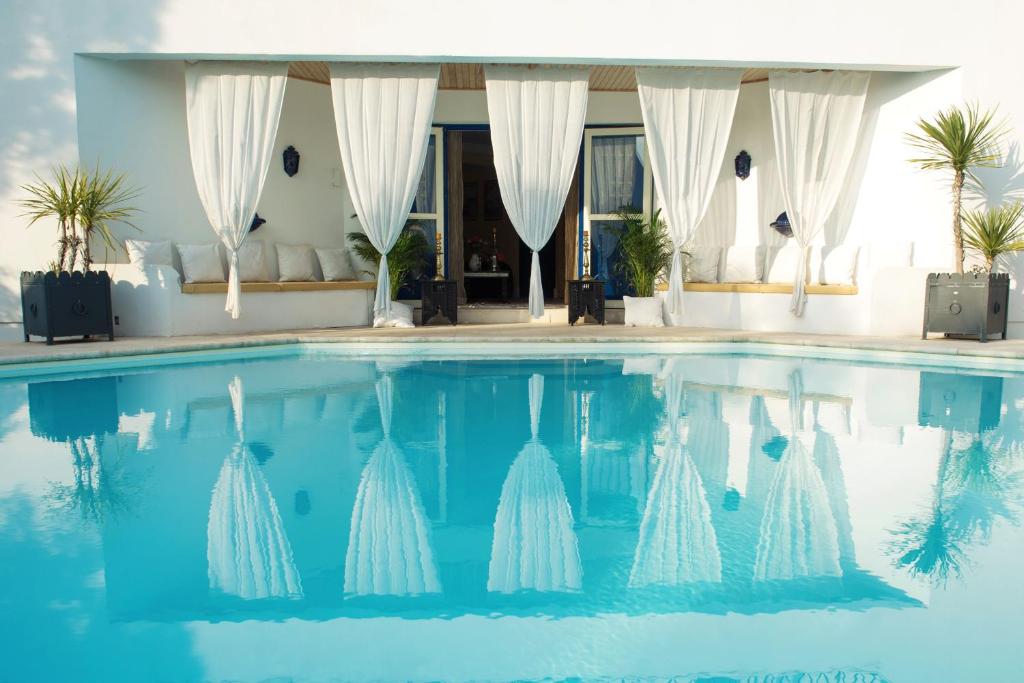 una piscina con una villa en el fondo en La Villa Majorelle, en Pertuis