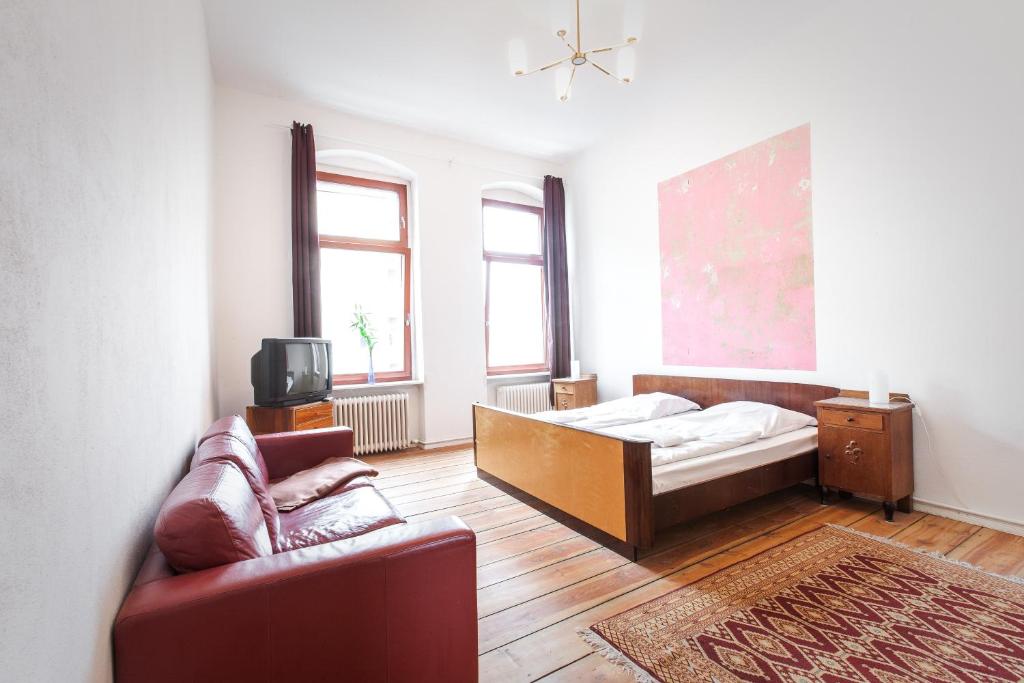 a bedroom with a bed and a couch and a tv at 3 Bedroom Apartment (ACELI) in Berlin