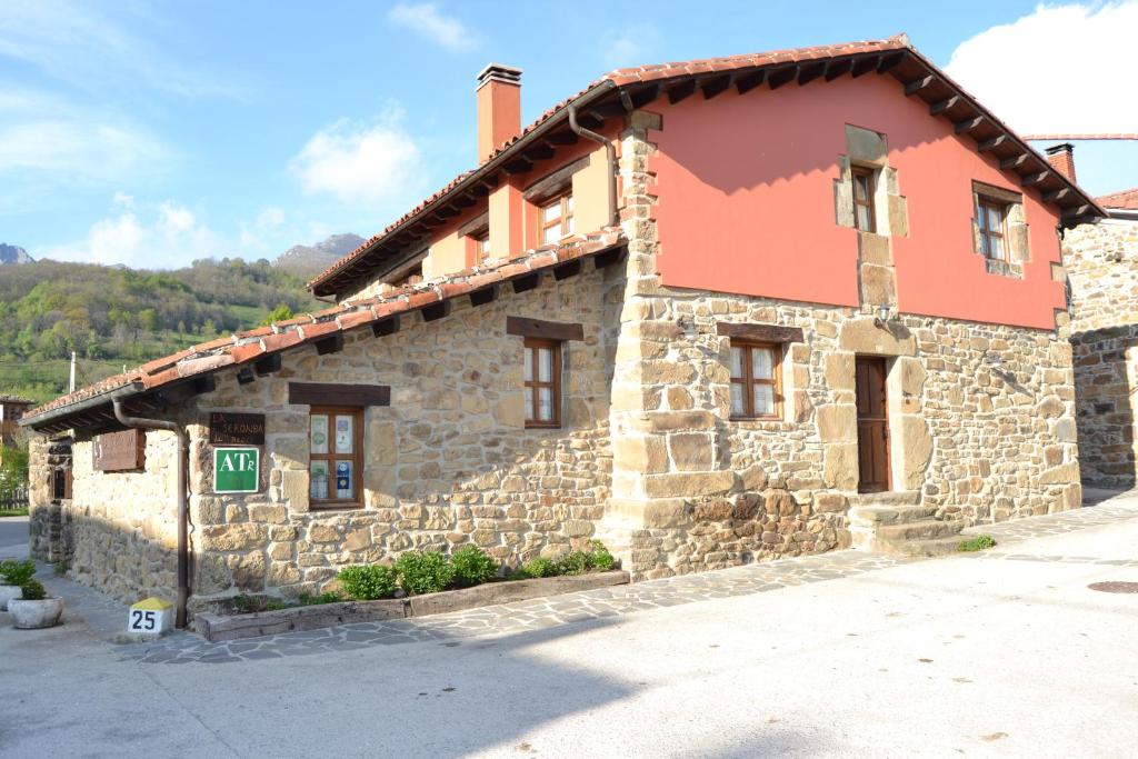 a stone building with a red roof at La Seronda de Redes in Bueres