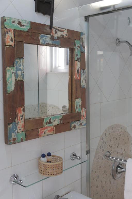 a bathroom with a shower and a mirror and a toilet at Altamont West Hotel in Montego Bay