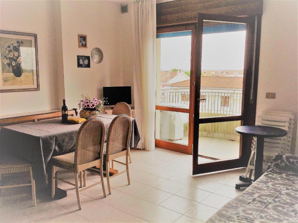 a dining room with a table and a view of a balcony at Bolognese Apart-Hotel 3 stelle vista mare in Caorle