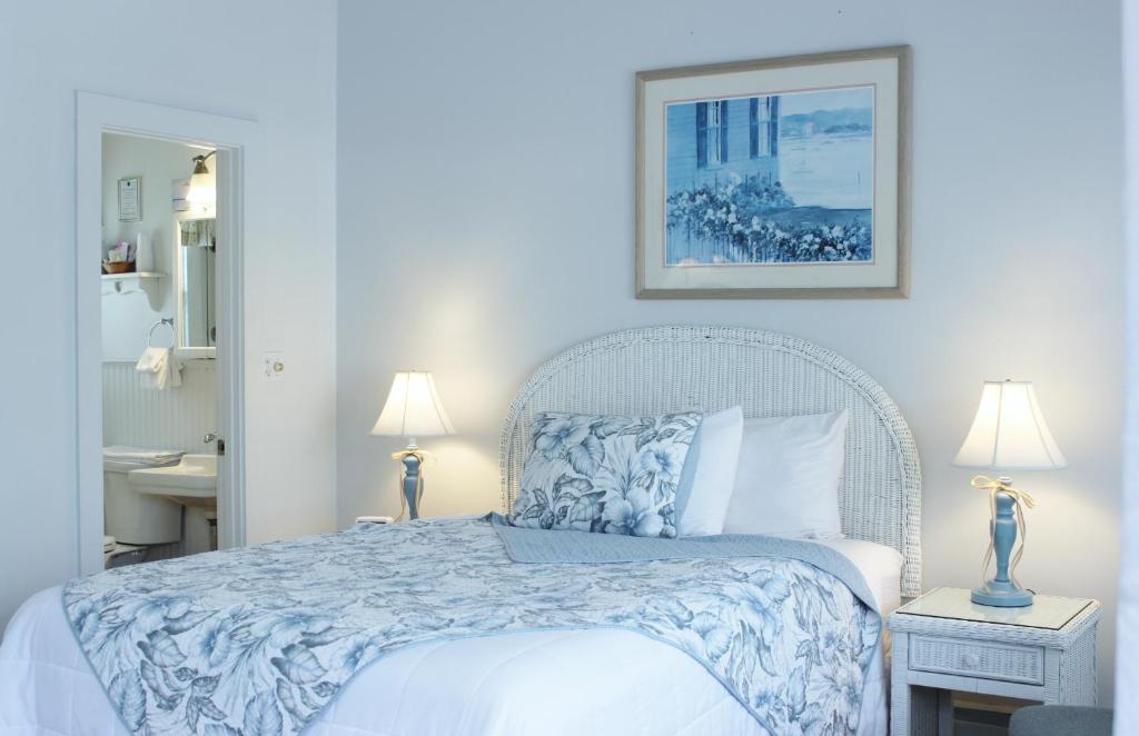 Schlafzimmer mit einem Bett mit einer blauen und weißen Bettdecke in der Unterkunft Red Horse Inn in Falmouth