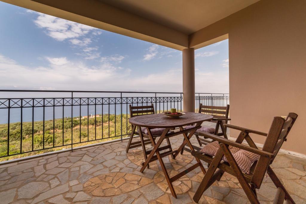 a table and chairs on a balcony with a view of the ocean at Regina apartments Simotata Sissia in Lourdata