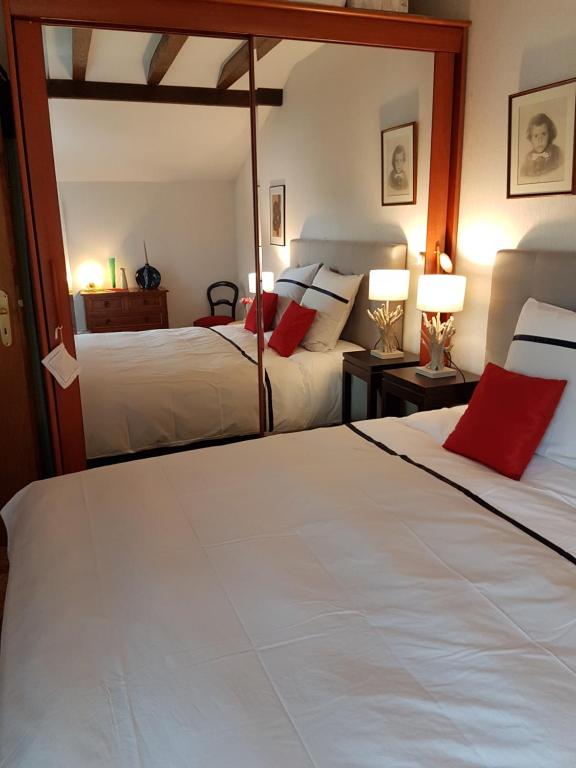 a bedroom with two beds with red pillows at Maison Luvy in Sundhoffen