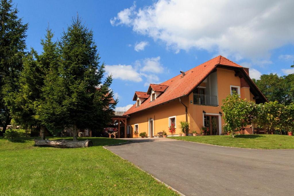 una casa amarilla con techo rojo en una carretera en Turistična kmetija Kaloh en Maribor