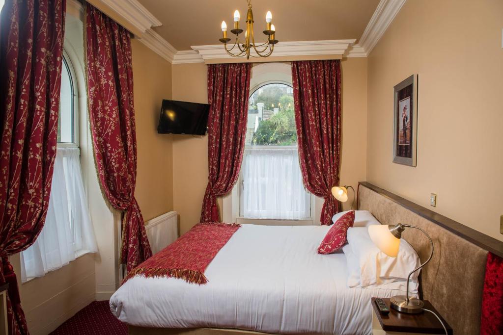 a bedroom with a bed with red curtains at Gabriel House Guesthouse in Cork
