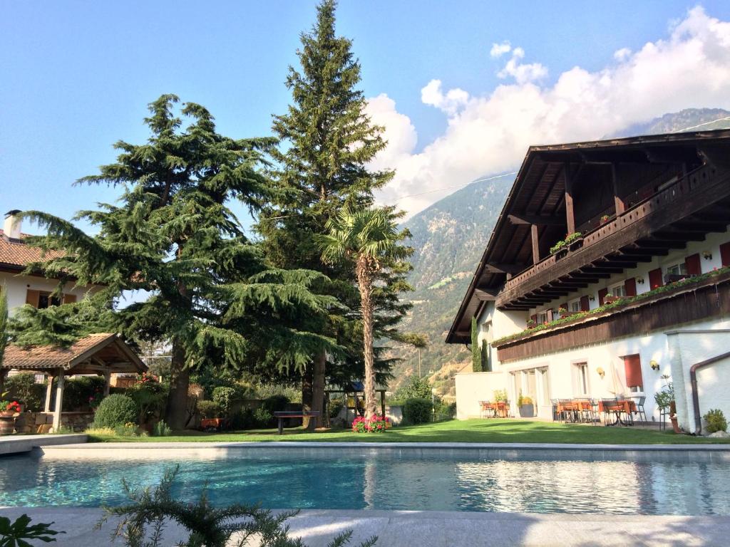 un complejo con piscina y montañas de fondo en Hotel Quellenhof, en Naturno