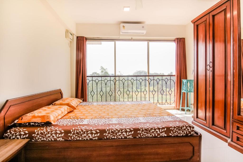 ein Schlafzimmer mit einem Bett und einem großen Fenster in der Unterkunft ROSA' Penthouse with POOL & TERRACE in Candolim